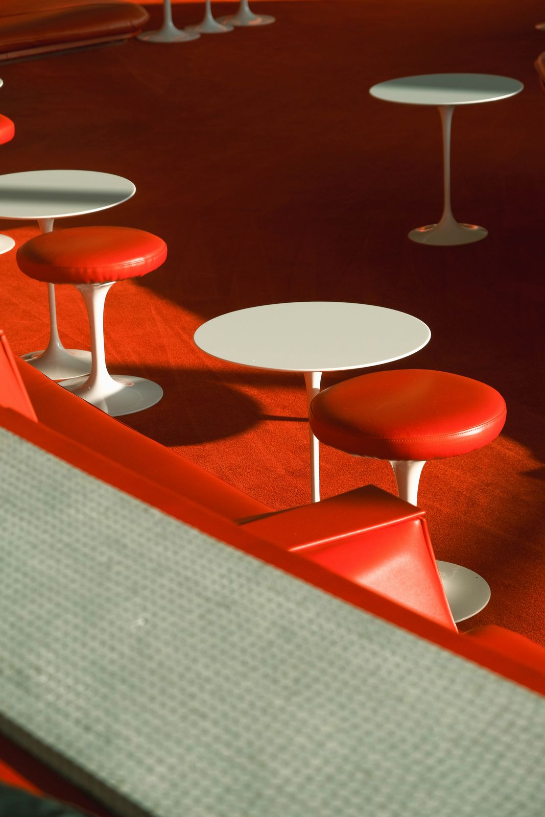 Retro red interior with white tulip tables and red stools
